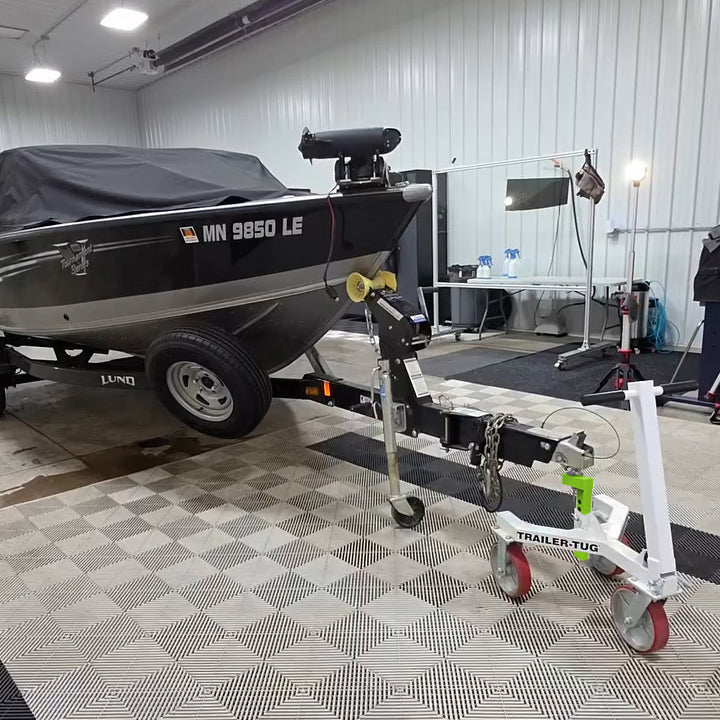 Boat on a trailer connected to a Trailer-Tug 3.0 trailer dolly inside a garage